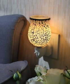 White Crackle Plug in Melt Warmer by Sense Aroma plugged inot a wall in a lounge and lit up beautifully